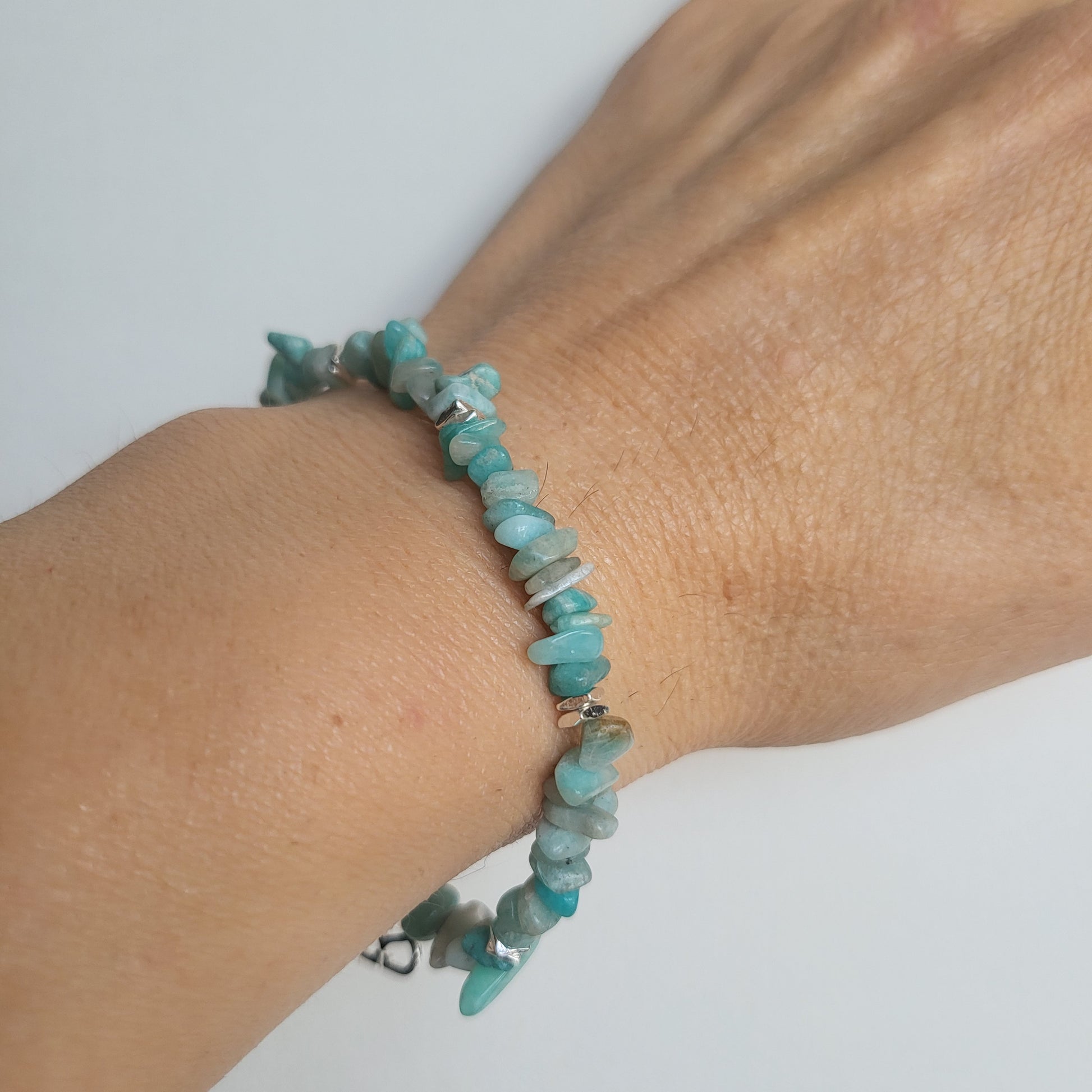 Amazonite beaded, elasticated bracelet on a wrist against a white background
