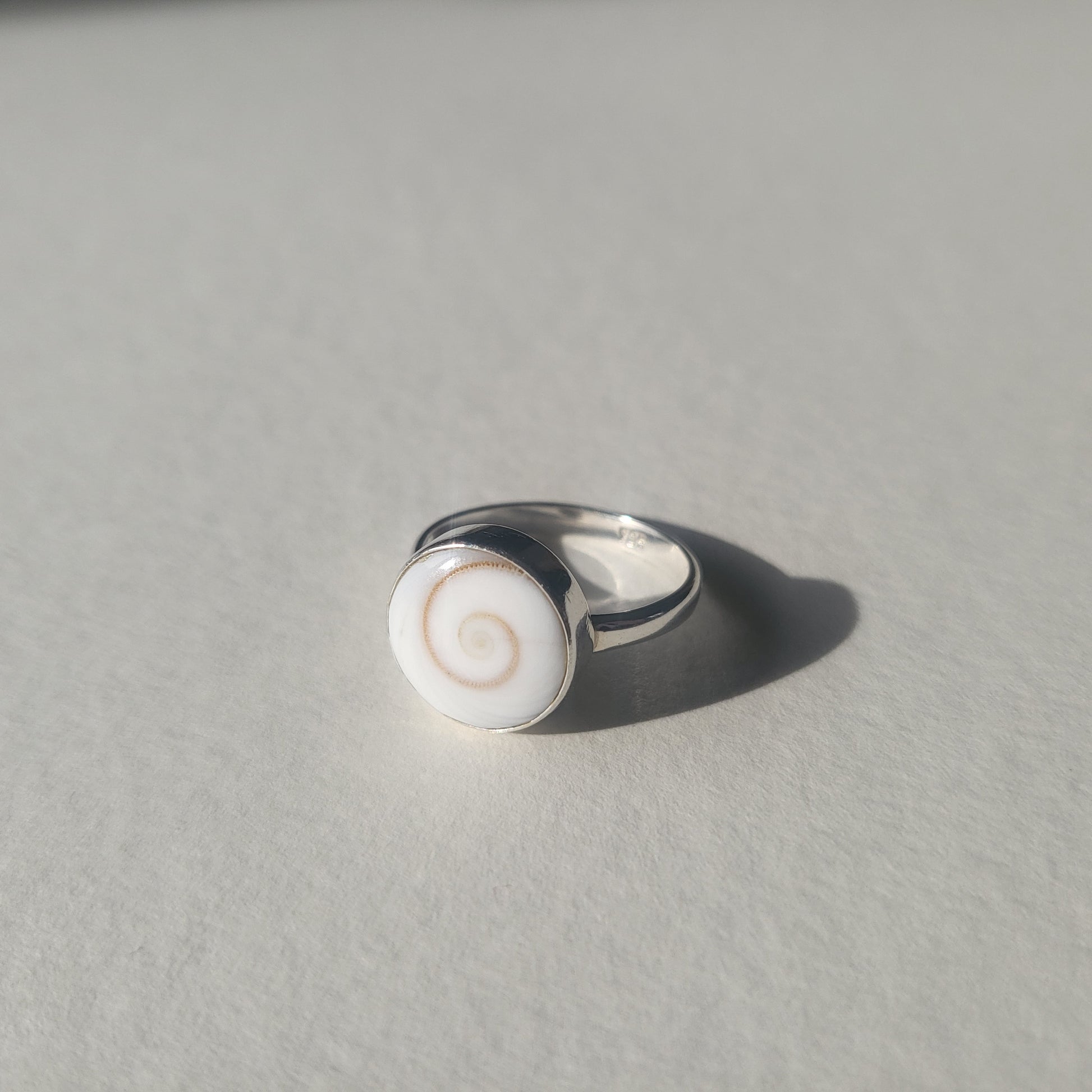Silver ring with a white circular shell design 
