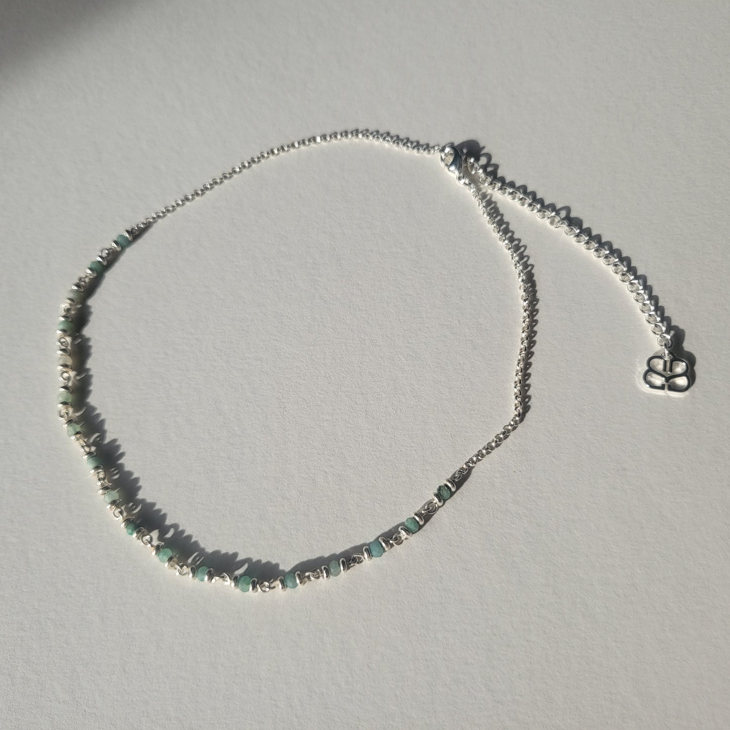 Necklace with small Amazonite stones on a light grey background