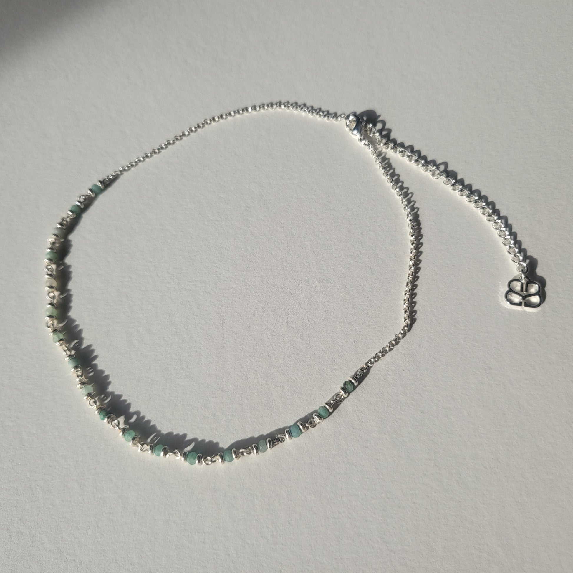 Necklace with small Amazonite stones on a light grey background