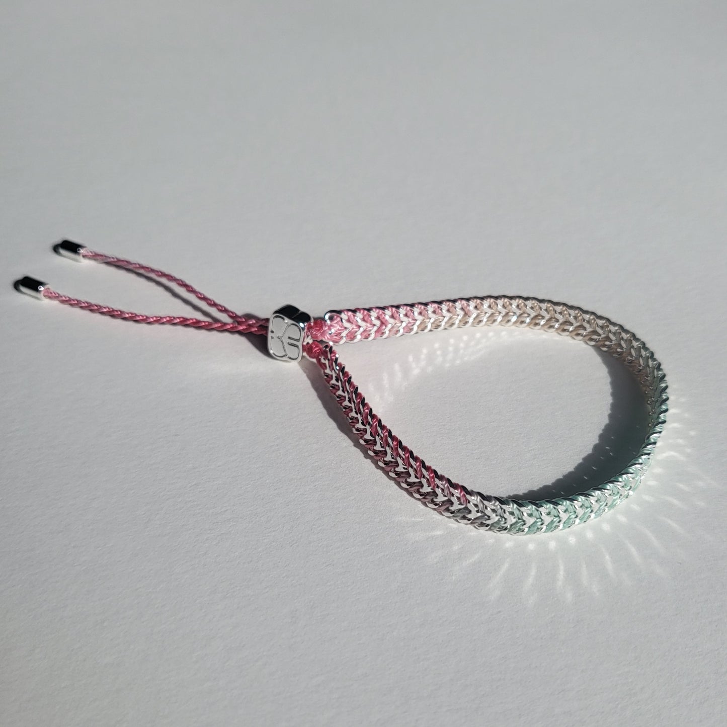 Bracelet with pink and silver design on a light gray background