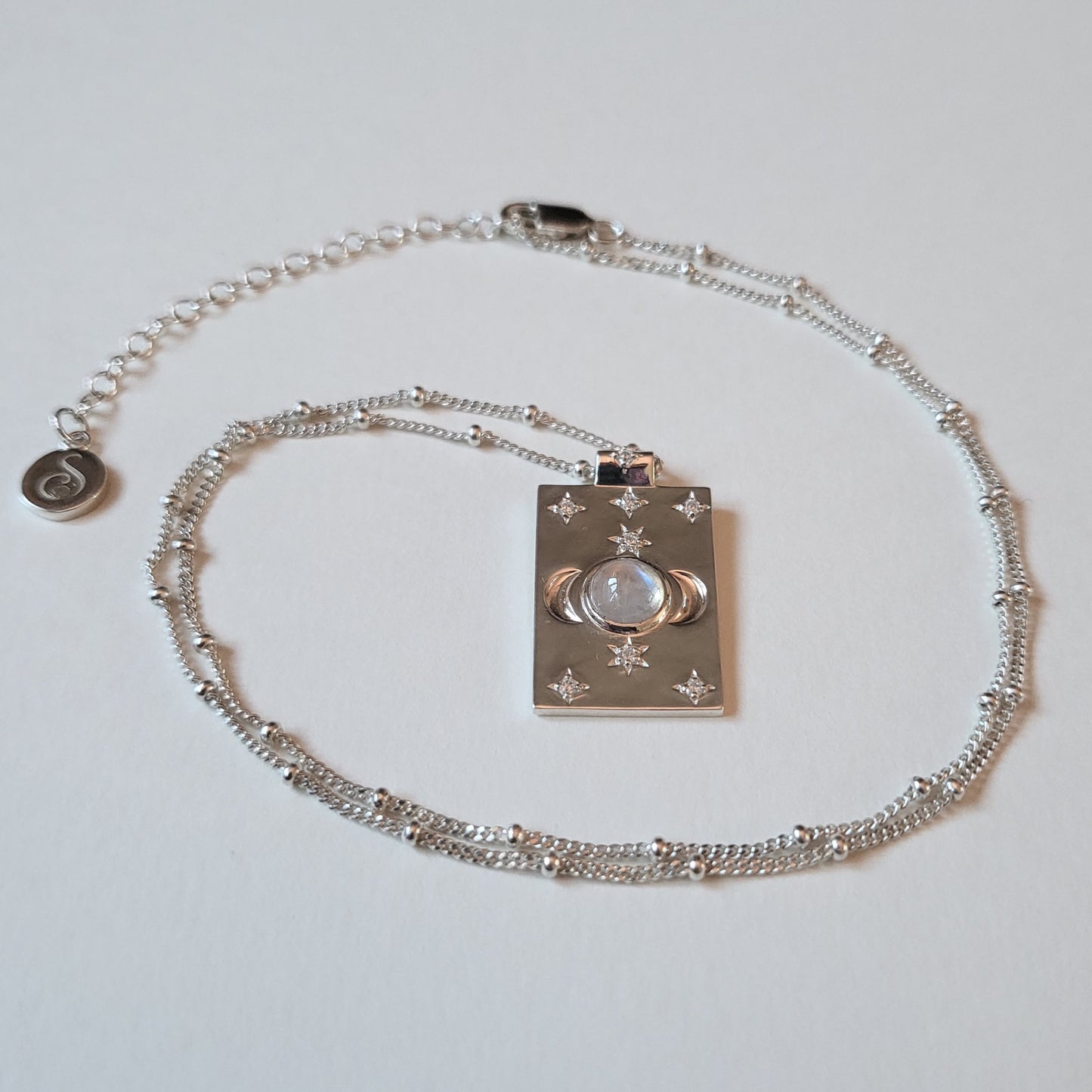 Silver necklace with a pendant on a light gray background